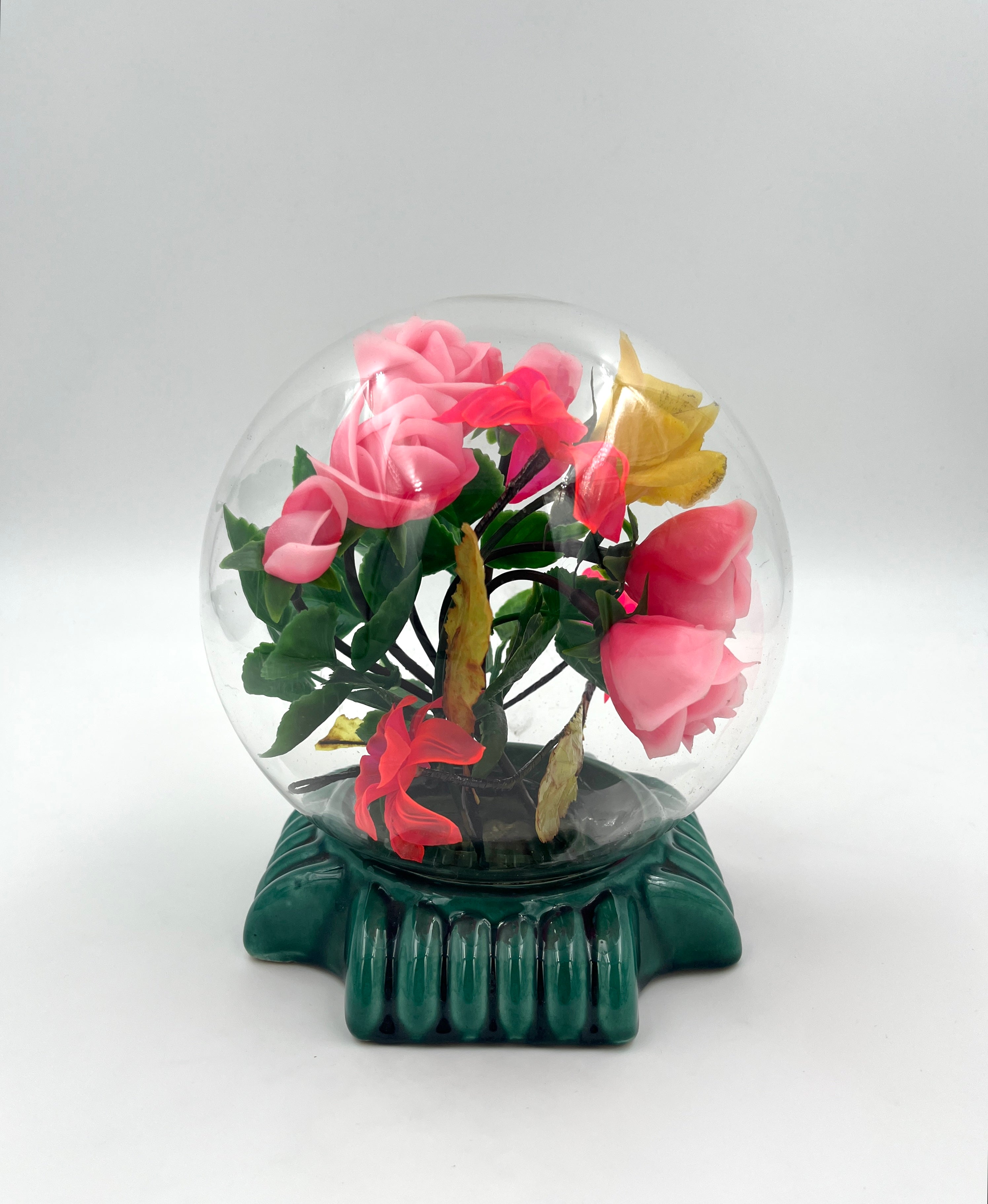 Le Rosarium France Decorative vintage floral arrangement under a clear glass dome with a glossy green base
