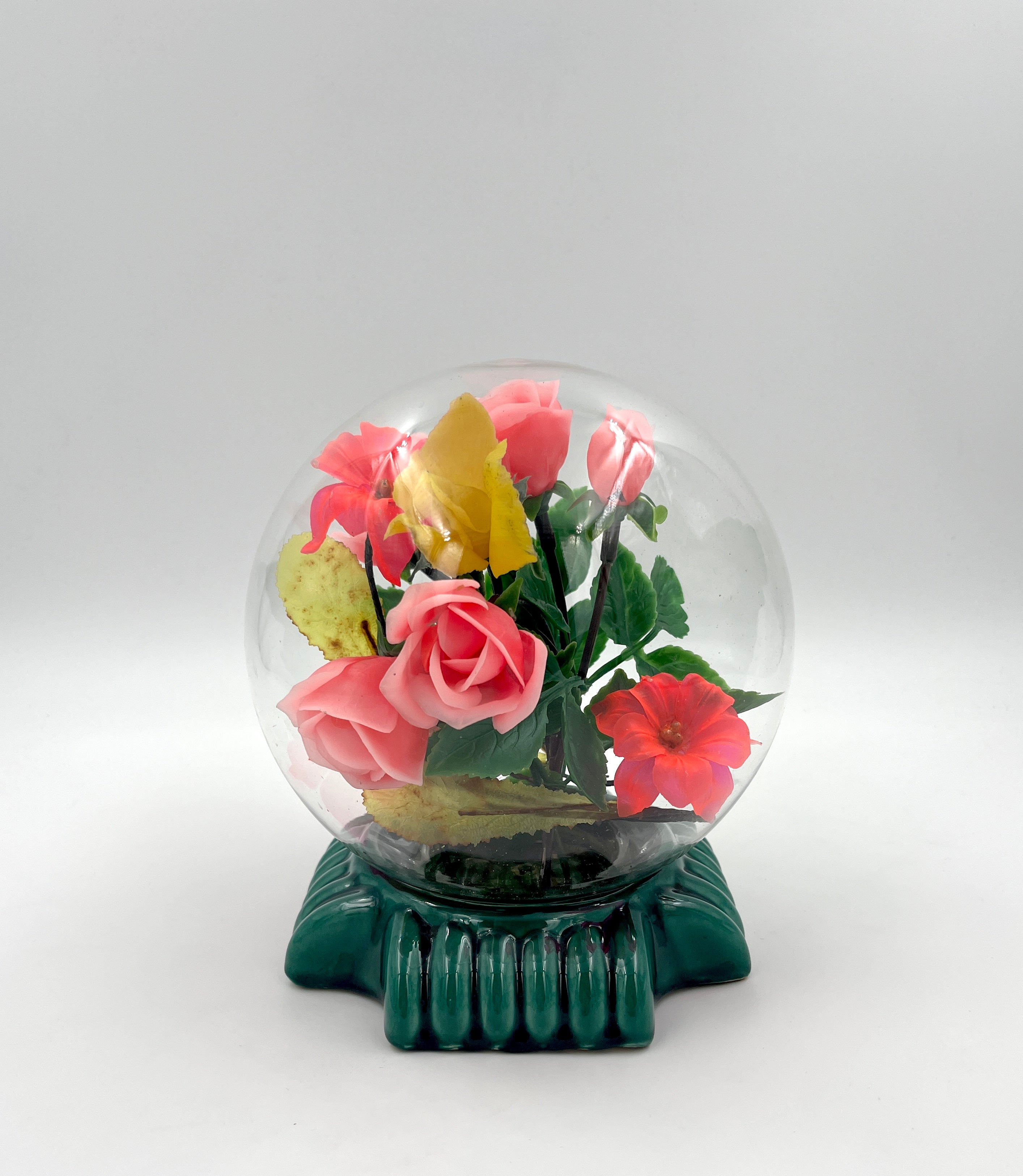 Le Rosarium France Decorative vintage floral arrangement under a clear glass dome with a glossy green base