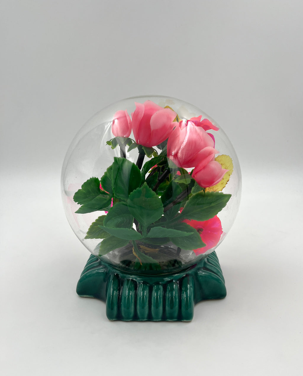 Le Rosarium France Decorative vintage floral arrangement under a clear glass dome with a glossy green base